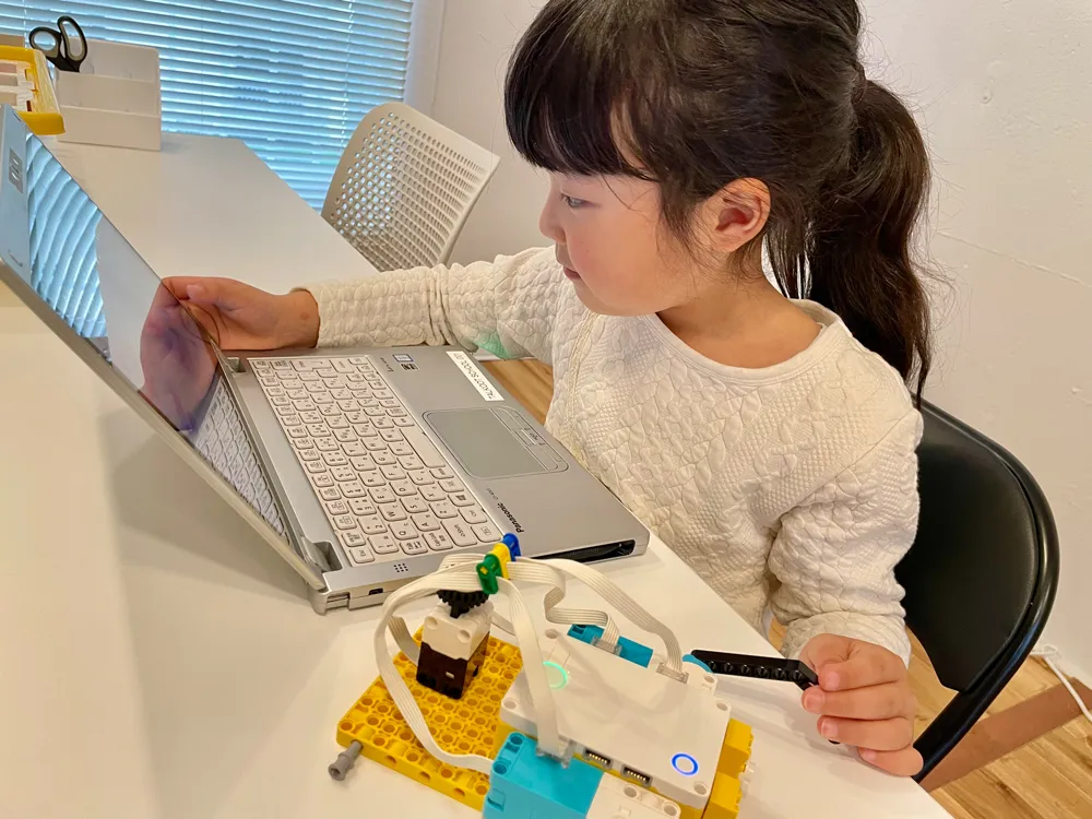 ノートパソコンとレゴのロボットで学ぶ女の子